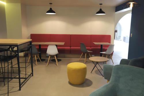 a waiting room with tables and a red bench at Casa Andina Standard Trujillo Plaza in Trujillo