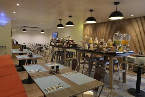 a restaurant with tables and chairs and a cafeteria at Casa Andina Standard Trujillo Plaza in Trujillo