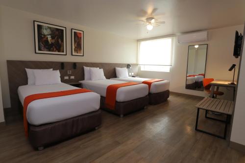 a hotel room with two beds and a mirror at Casa Andina Standard Trujillo Plaza in Trujillo
