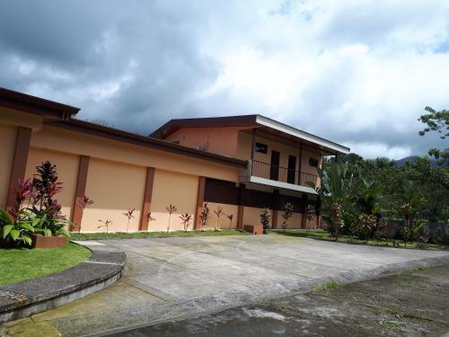 a house with a driveway in front of it at Aunty Arenal Lodge in Fortuna