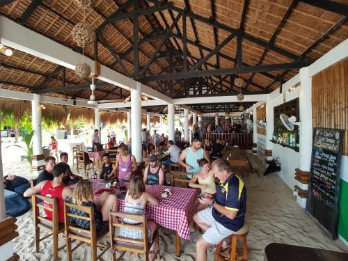 un grupo de personas sentadas en una mesa en un restaurante en Evolution Dive and Beach Resort, en Isla de Malapascua