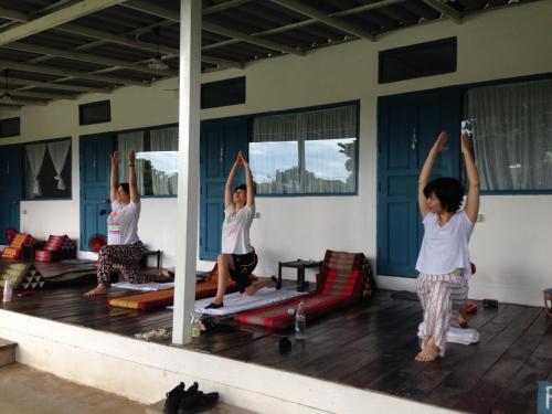 a group of people doing yoga in a room at Ban Narai River Guesthouse in Chiang Mai