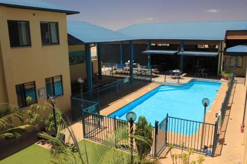 a large swimming pool next to a building at Ningaloo Coral Bay Backpackers in Coral Bay