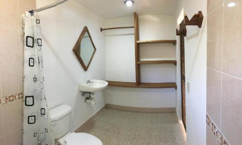 
a bathroom with a toilet a sink and a mirror at Casa Lomita in Puerto Ángel
