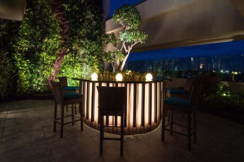a bar with chairs and a table on a balcony at Dusit Thani Manila in Manila