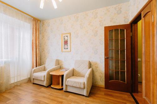 トムスクにあるАпартаменты Елизаровых 10のリビングルーム(椅子2脚、テーブル付)