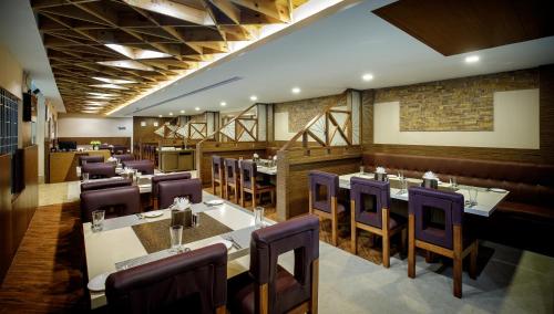 une salle à manger avec des tables et des chaises violettes dans l'établissement Hotel ARJUNAA, à Rameswaram