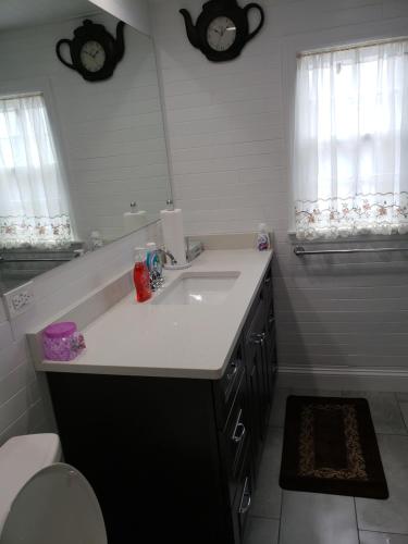 a bathroom with a sink and a bath tub with a mirror at Comfortable holiday homestay in Bronx