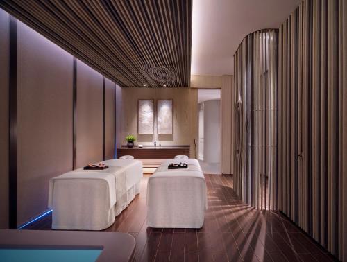 two beds in a room with white tables at Grand Hyatt Xi'an in Xi'an
