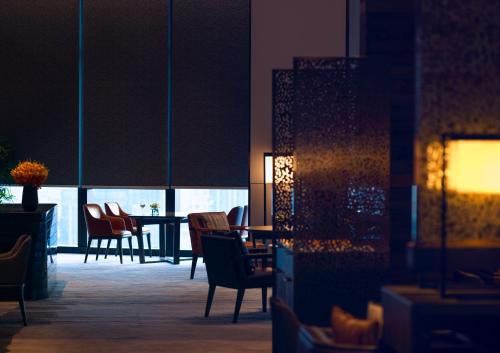 a room with chairs and a table and a dining room at Grand Hyatt Xi'an in Xi'an