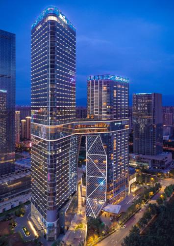 a tall building with a bridge in front of a city at Grand Hyatt Xi'an in Xi'an
