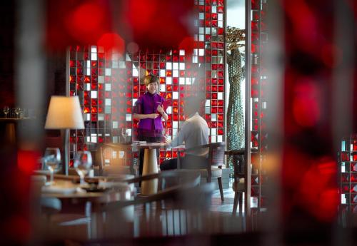 a man standing in front of a mirror in a restaurant at Grand Hyatt Xi'an in Xi'an