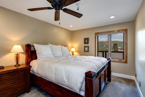 a bedroom with a bed with a ceiling fan and a window at Quitting Time Condo in Park City