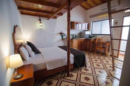 a bedroom with a canopy bed and a kitchen at Epoca Iquitos in Iquitos