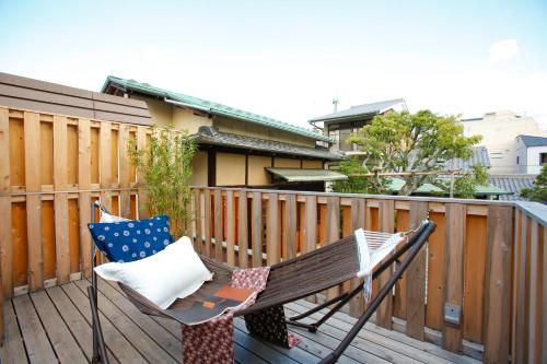 una terraza de madera con una silla sobre una valla en Kyoto Nishijin Shichiban Tei (No7) en Kioto