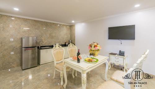 a dining room with a table and a kitchen at Tan An Palace in Hai Phong
