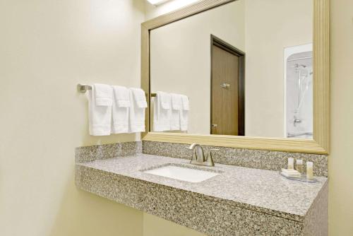 y baño con lavabo y espejo. en Days Inn by Wyndham Collinsville St Louis, en Collinsville