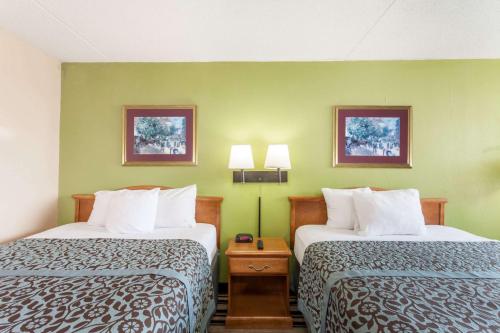 two beds in a hotel room with green walls at Days Inn by Wyndham Jackson in Jackson