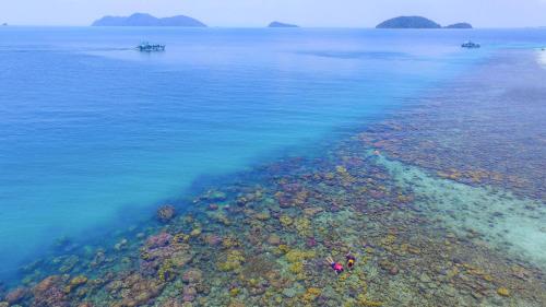 an aerial view of the ocean with rocks and reefs at Baan Chan Lay Koh Chang in Ko Chang