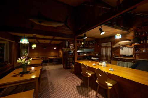 a restaurant with wooden tables and chairs and a bar at Lake village donaludo Pension in Kitashiobara