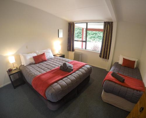 a hotel room with two beds and a window at Mt Aspiring Holiday Park in Wanaka