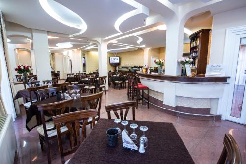 a restaurant with tables and chairs and a bar at Hotel Imperial Premium in Timişoara