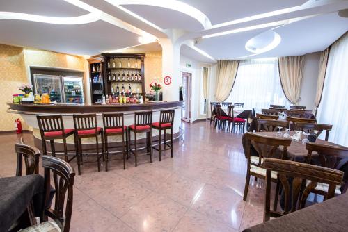 a restaurant with a bar and some tables and chairs at Hotel Imperial Premium in Timişoara