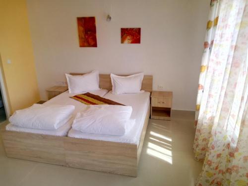 a bedroom with a bed with white sheets and pillows at Camere De Inchiriat Carpati in Hunedoara