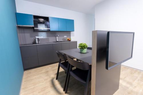 a kitchen with a black table and blue cabinets at Beachwell in Pelhřimov