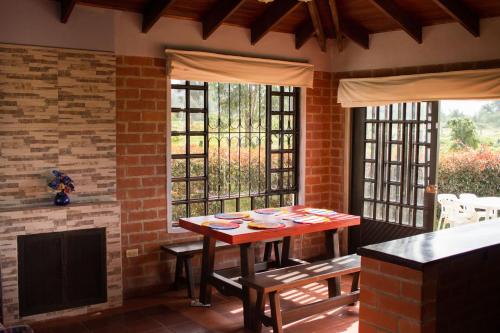 uma sala de jantar com uma mesa e uma lareira em Cabaña Campestre El Refugio em Paipa