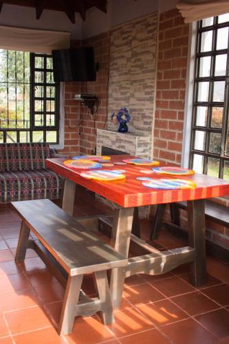 a wooden table with a bench in a room at Cabaña Campestre El Refugio in Paipa