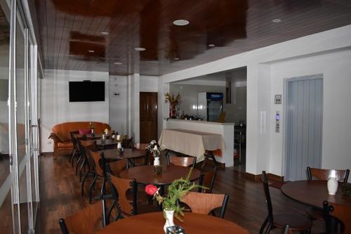 a restaurant with tables and chairs and a bar at Casa De Luz Hotel in Machu Picchu