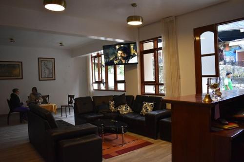 a living room with a couch and a tv at Casa De Luz Hotel in Machu Picchu