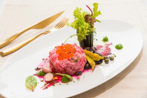 a white plate of food on a table at Kydon The Heart City Hotel in Chania Town
