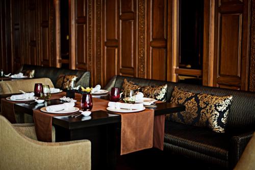 a restaurant with two tables and a couch and chairs at Taj City Centre Gurugram in Gurgaon