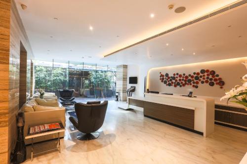 a living room with a couch and a desk at The Empresa Hotel in Mumbai