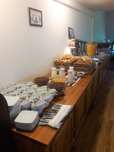 un lungo buffet con ciotole, piatti e altro cibo di PAN Dom Pracy Twórczej w Wierzbie a Wierzba