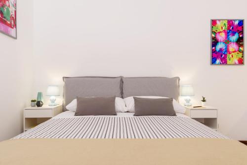 1 dormitorio con 1 cama grande y 2 mesitas de noche en Stampa Flexyrent Apartment, en Milán