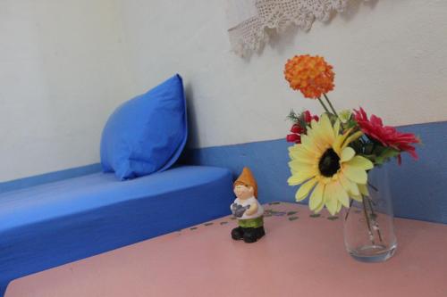a figurine next to a vase with flowers on a table at Pai Modern House in Pai