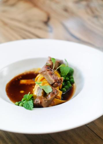 a plate of food with meat and vegetables on a table at Jambuluwuk Oceano Seminyak Hotel in Seminyak