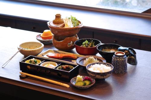 un tavolo con vari piatti di cibo sopra di Ryokan Nenrinbo a Kyoto