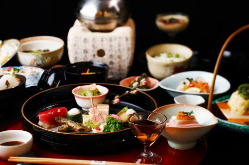a table topped with bowls and plates of food at Ryokan Nenrinbo in Kyoto