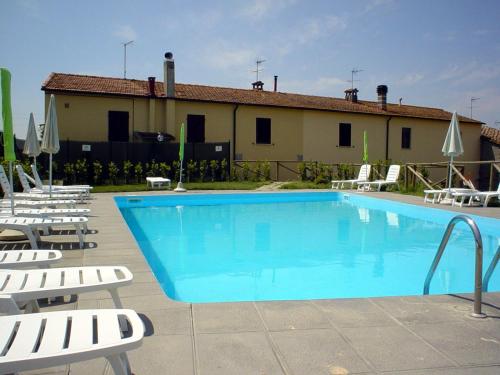 una gran piscina con sillas y un edificio en Casa Roffi Esposito, en Pieve di Santa Luce