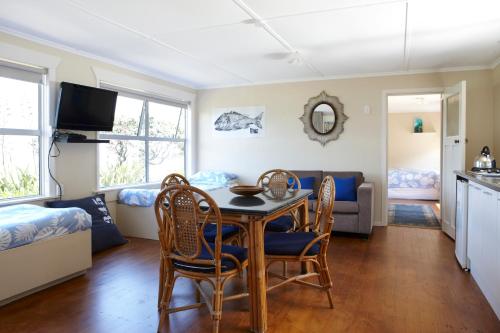 a living room with a table and chairs and a couch at Tipi and Bobs Waterfront Lodge in Tryphena