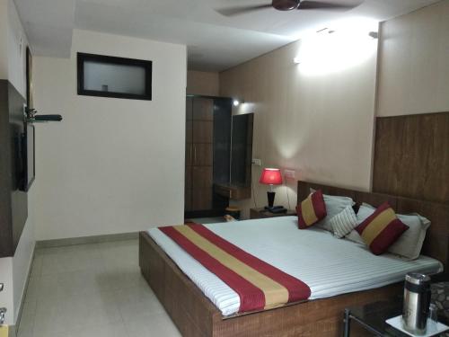 a bedroom with a bed and a tv on the wall at Hotel Palace in Amritsar