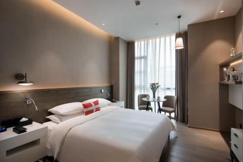 Postel nebo postele na pokoji v ubytování Swisstouches Guangzhou Hotel Residences
