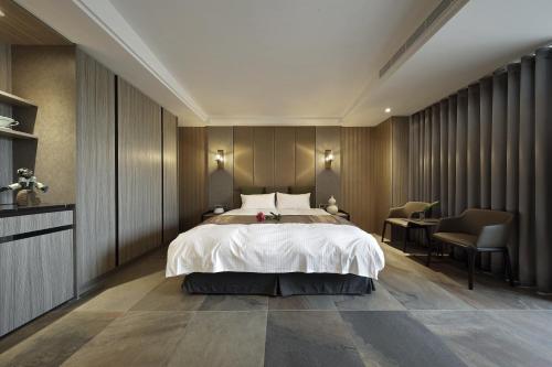 a bedroom with a bed and a table and chairs at 正巧文旅 蔬食友善旅館 in Caotun