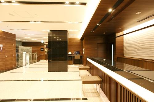 an office lobby with a reception counter and benches at Dormy Inn Kagoshima in Kagoshima