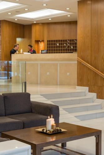 a lobby with a couch and a candle on a table at Kydon The Heart City Hotel in Chania Town