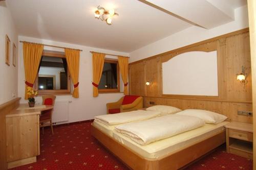 a bedroom with a large bed and a desk at Zollhof in Vipiteno